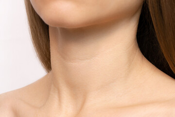 Close-up of creases and wrinkles on the neck of a young woman. Age-related skin changes, lines or...
