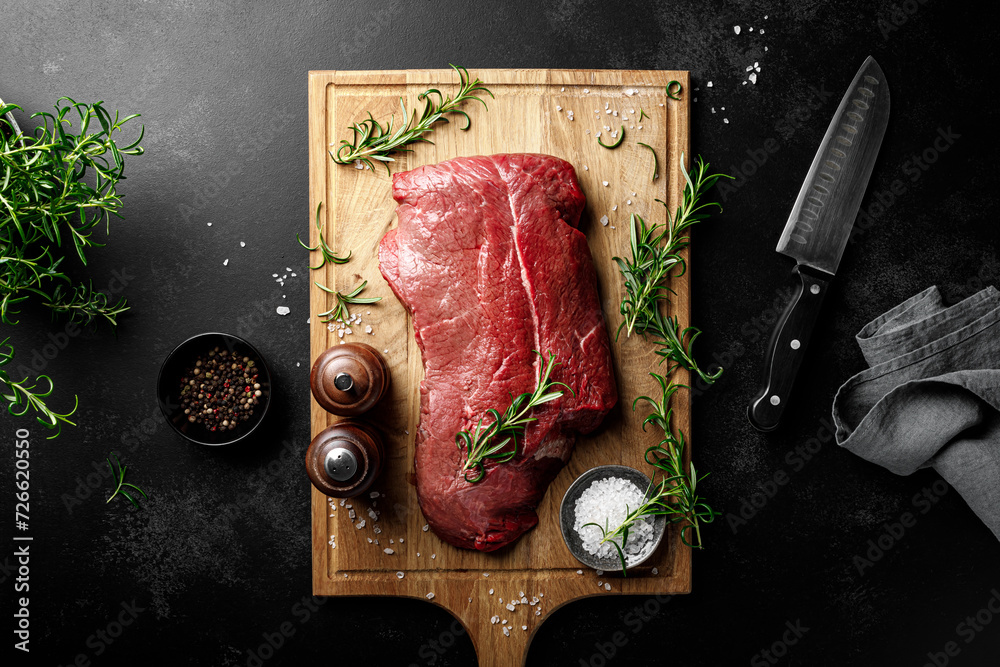 Canvas Prints beef meat entrecote on a cutting board, raw beef meat fillet on black background, top view