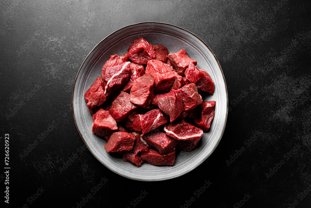 Poster beef meat entrecote sliced, raw beef meat fillet on black background, top view