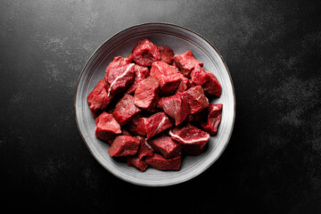 Beef meat entrecote sliced, raw beef meat fillet on black background, top view