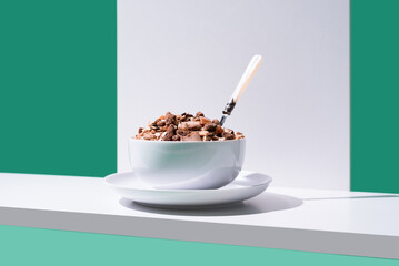 Cereal de granola muesli en un tazón blanco con cuchara sobre fondo verde 