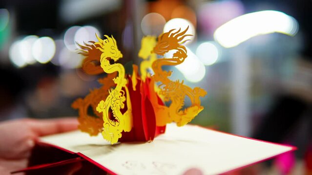 Symbol of the Chinese Year of the Dragon in origami on opened greeting card. Traditional celebration classic winter holidays of New Year in Asia where streets decorated in Oriental style lunar year
