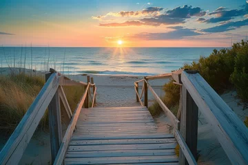 Wandaufkleber Sunset at the beach, Walking towards the ocean, A serene boardwalk scene, The path to a beautiful sunset. © Jevjenijs