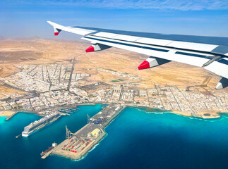 Aerial view over the beautiful coastline of Fuerteventura island from the window of an aircraft with the blue clean Atlantic Ocean water in Canary Islands