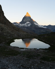 Wschód słońca pod jeziorem alpejskim z widokiem na Matterhorn, Szwajcaria - 726634189