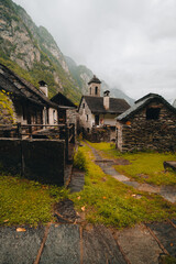 Sonogno village in Swiss alps with waterfall nearby. - 726634352