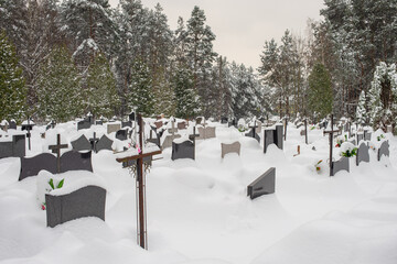 Granite graves under the snow in winter cemetery