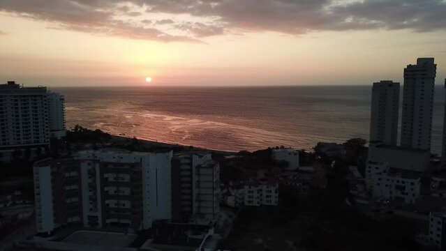 Atardecer en la playa de Santa Marta - Colombia, con el oc&eacute;ano y edificios cercanos 2.