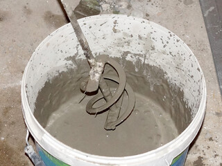 construction mixer in a bucket with cement mortar