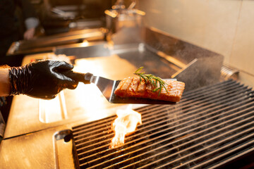 close-up of a chef holding an appetizing juicy fried piece on a spatula in a restaurant kitchen