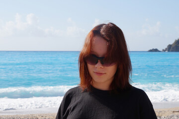 portrait of a smiling teenage girl with brown hair against the background of the sea horizon