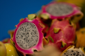 detail of the pitaya fruit cut in half along with other exotic and tropical fruits