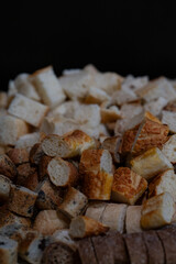 still life of pieces of different types of bread on a black background