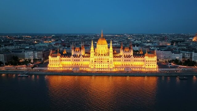 Residence of Hungarian Parliament, Budapest night city lights illuminated aerial view slide drone turn backdrop of sunset evening summer. National building symbol view from other bank of Danube River