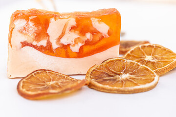 A bar of organic soap, orange soap with natural ingredients on white background, copy space. Healthy skin care.