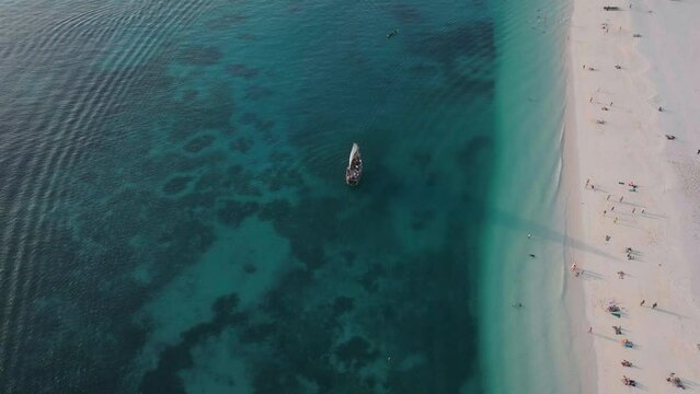 Tourists boat sails near the wonderful beach of Zanzibar, summer concept, carefree holiday, Africa, Tanzania.