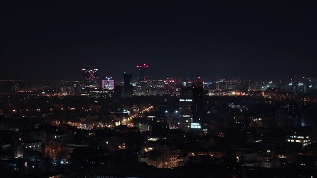 Fly over night shot in urban area. Night Aerial View over Bucharest. Cityscape view over city. Bucharest at night. City Skyline In Romania. Business Skyscraper buildings. Film grain texture.
