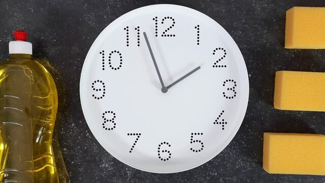 Cleaning time. 2 o'clock. Afternoon. White clock face on dark background with yellow kitchen sponges and bottle of detergent liquid. Cleanup and washing time concept.