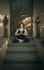 woman meditating near closed doors