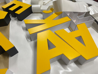 Making letters from plastic to advertise the brand.Interior advertising in production. Letters made...