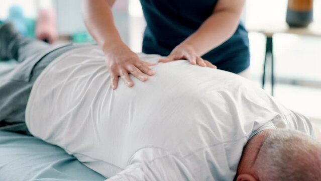 Physiotherapy, back massage and chiropractor with senior man in medical office at clinic. Rehabilitation, patient and closeup of healthcare worker helping elderly male person by healing muscle pain.