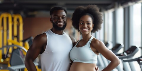 Muscular man and pregnant African American woman in a gym, family couple does sport together