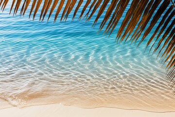 Fototapeta na wymiar Idyllic top view of water surface with serene tropical leaf shadow on pristine white sand beach