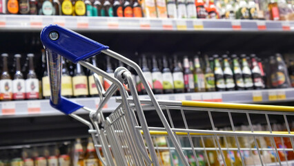 Close-up of a steel shopping trolley in alcohol department