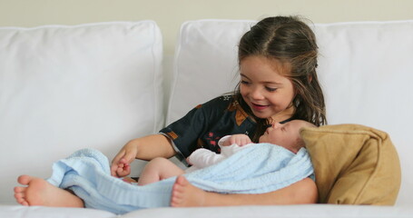 Big sister and little newborn baby infant together