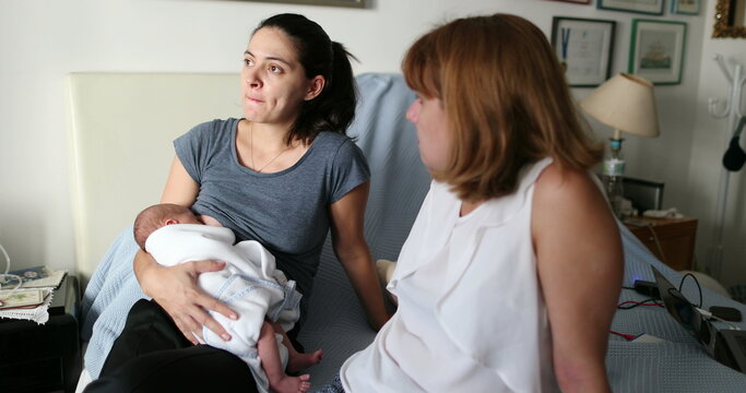 Female friends talking about maternity inside baby bedroom