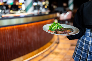 waiter hold in his hands ready beef steak ribeye meat