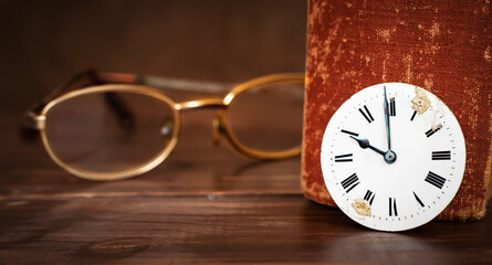 Eyeglasses with old book and clock face. Storytelling, story time background.
