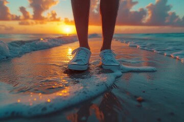 A lone figure stands on the beach at sunrise, their feet buried in the sand as they gaze out at the endless ocean, the sky painted with vibrant hues of pink and orange, a pair of worn-out flip flops 