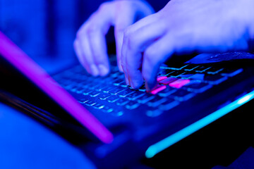 close-up of hands of hacker pressing keys on keyboard in data center vulnerable cyber security...