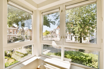 Bright room with open windows overlooking a residential area
