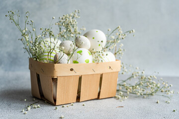 Decorative Easter eggs in a basket with spring flowers
