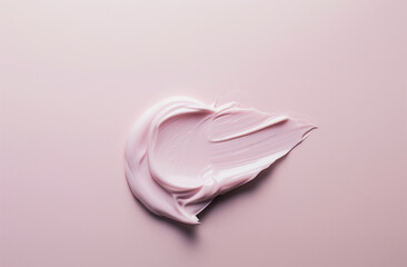 Smear of pink creamy cosmetic product on a pink background. Beauty and skincare concept with a close-up view and space for text.