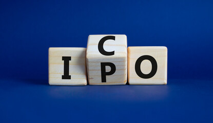 ICO and IPO symbol. Wooden cubes with words ICO - initial coin offering and IPO - initial public offering. Beautiful deep blue background. Business concept. Copy space