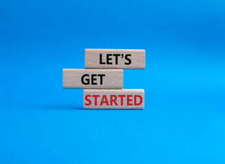 Lets get started symbol. Concept words Lets get started on wooden blocks. Beautiful blue background. Business and Lets get started concept. Copy space.