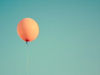 Obraz premium One bright balloon on a string, clear sky.