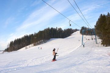 Ski season. Snow slope with T-bar and group of people. Panoramic view.