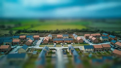 Poster Tilt-shift aerial view of a suburban neighborhood with houses and roads, creating a miniature effect. © Vas