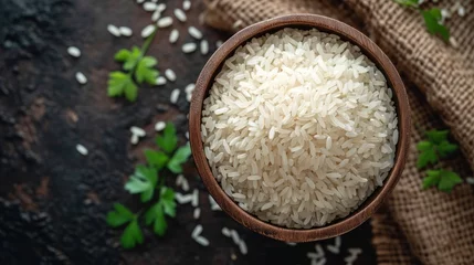 Foto op Canvas  a wooden bowl filled with rice sitting on top of a table next to a burlied bag of rice. © Olga