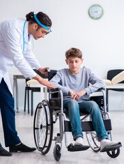 Fototapeta na wymiar Young male doctor pediatrist and boy in wheel-chair