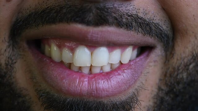 Detail macro close-up of smile, one hispanic black 20s man mouth with wide grin tight closeup detail