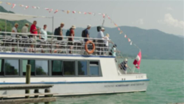 tourists leaving ship in alpine lake Mondsee, Austria