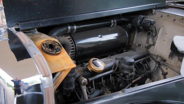 Old carbureted engine in engine compartment of retro old car. Close up