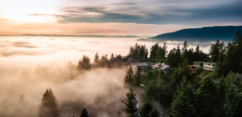 Residential Homes on top of mountain with fog. Sunset.