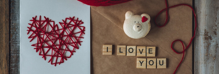 Concept of love message. I love you words written in wooden blocks. Idea for making handmade greeting cards with wooden red heart for Valentine's Day. Sweet cute bear for breakfast, envelope banner