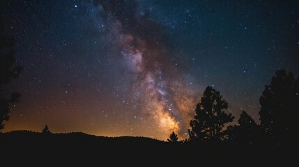  the night sky is filled with stars and the milky shines brightly above the trees in the foreground of the image.